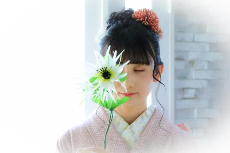 白い花を手にした和装花嫁のポートレート